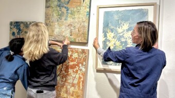 Women hang paintings at Industrial Center Building Art in Sausalito