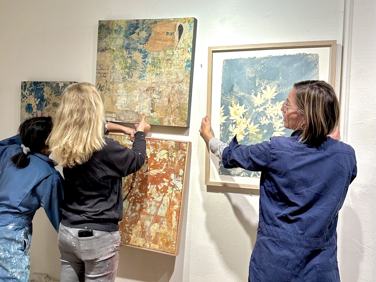 Women hang paintings at Industrial Center Building Art in Sausalito