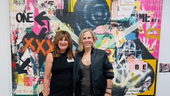 Two women stand in front of modern art piece at ICB Open Studio, a community event in Marin