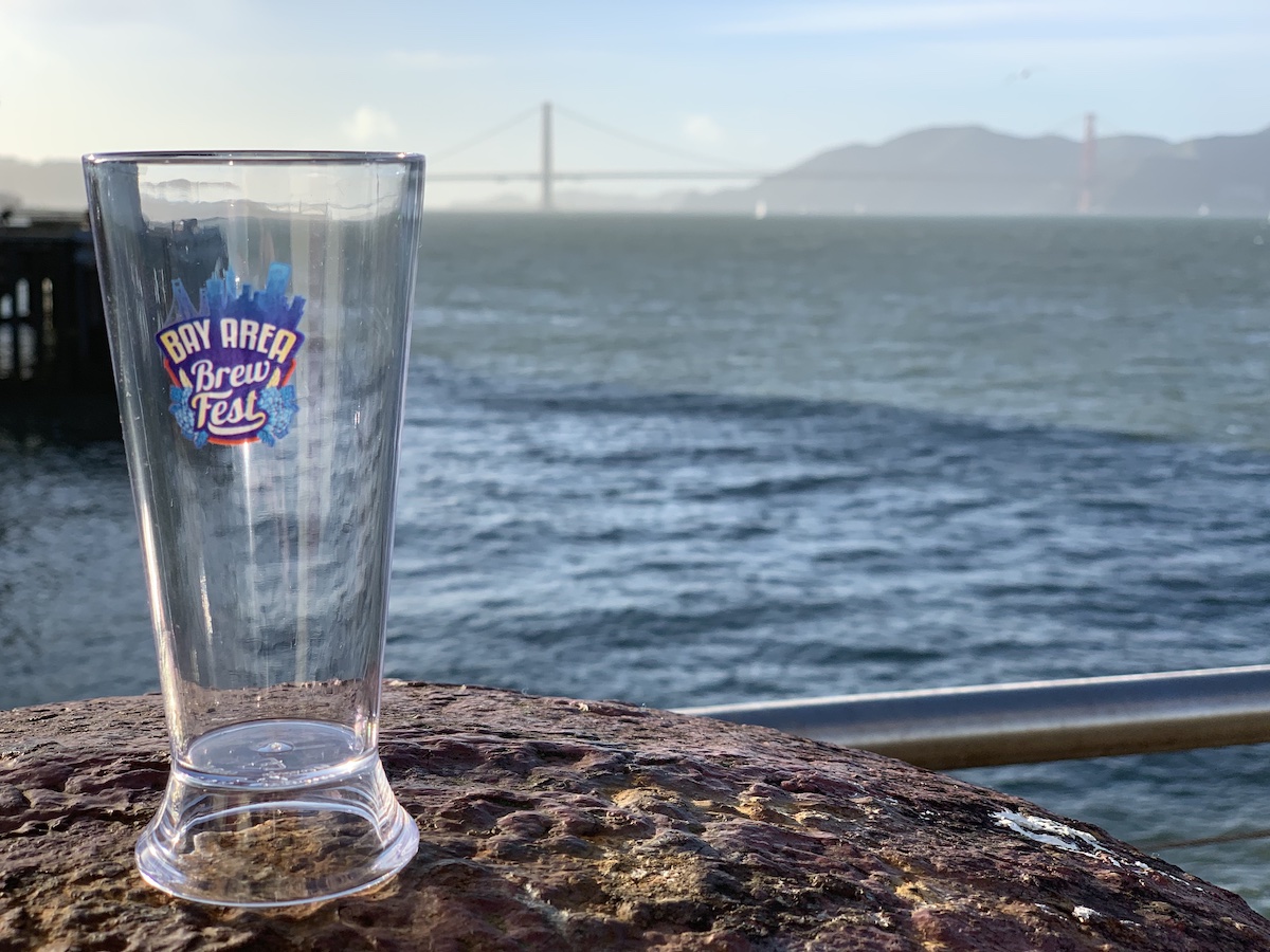 Empty pint glass sits in front of a view of the Golden Gate Bridge for Bay Area Brew Fest in San Francisco