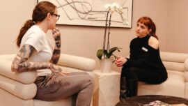 Worker for Aesthetx sits with client in consultation