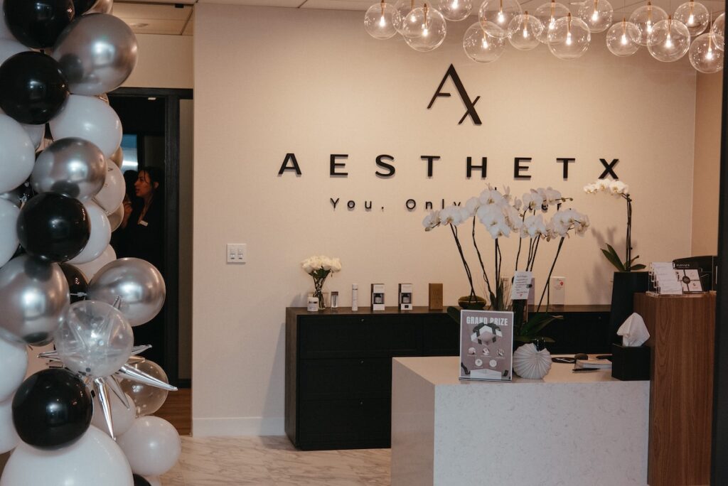 Lobby of Aesthetx with logo on the wall and balloons
