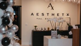 Lobby of Aesthetx with logo on the wall and balloons