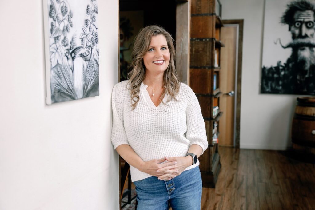 A woman leaned against a wall posing for a picture.