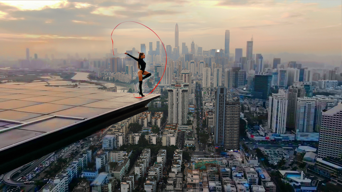 Acrobat woman stands on precipice of a building in the film Skywalkers: A Love Story. 