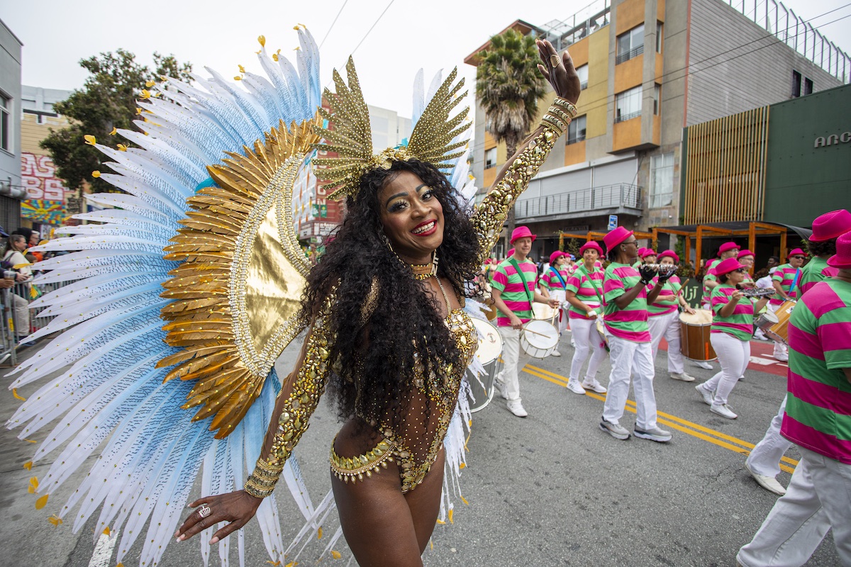 Dancer in costume with gold feathers at the Carnaval San Francisco parade