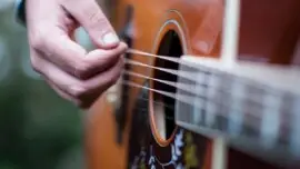 Hand strums acoustic guitar, live music in Marin this May