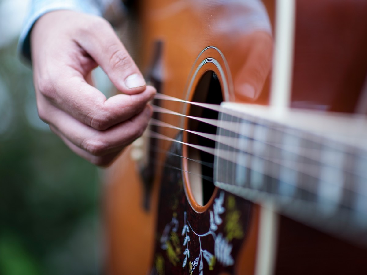 Hand strums acoustic guitar, live music in Marin this May