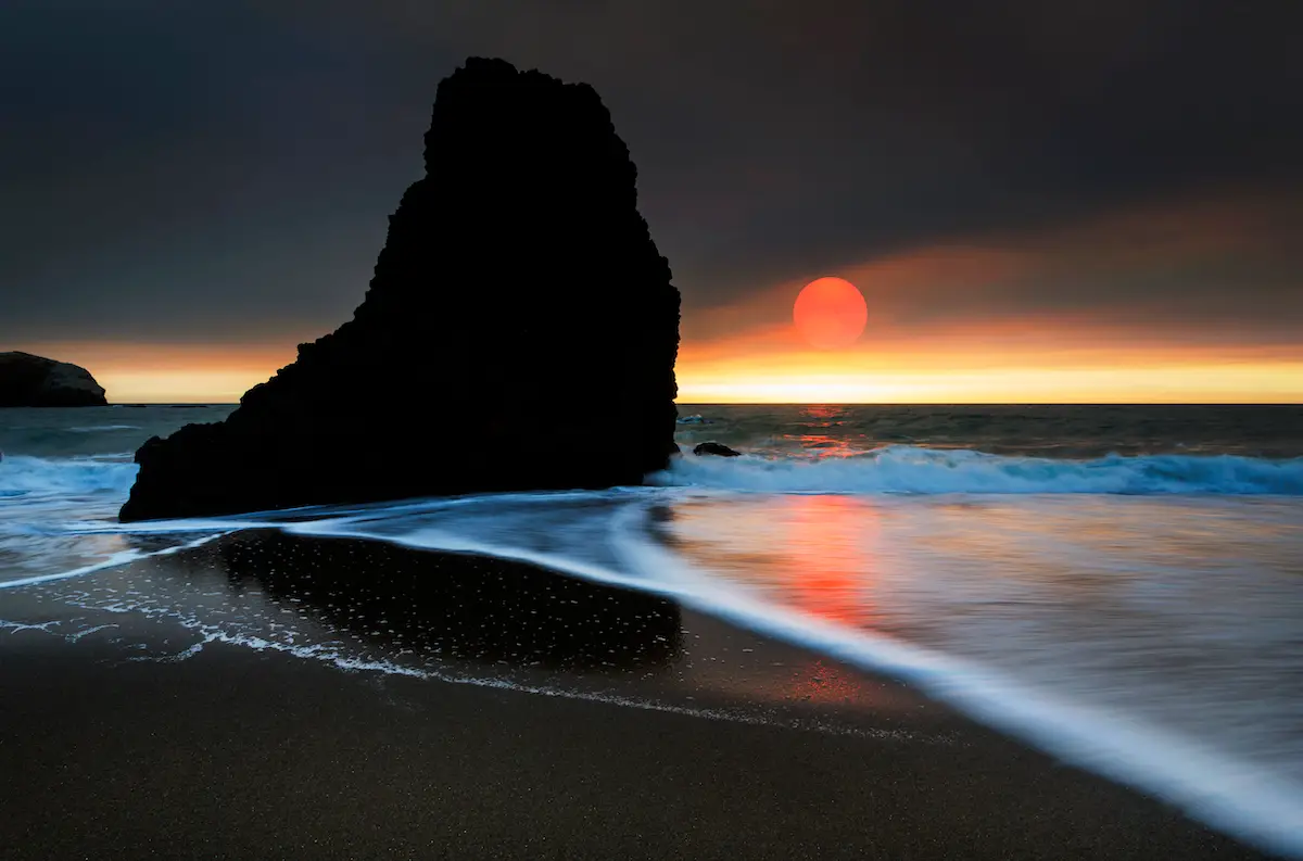A red sunset at Rodeo Beach due to wildfire smoke, nature photography by Jay Tamang
