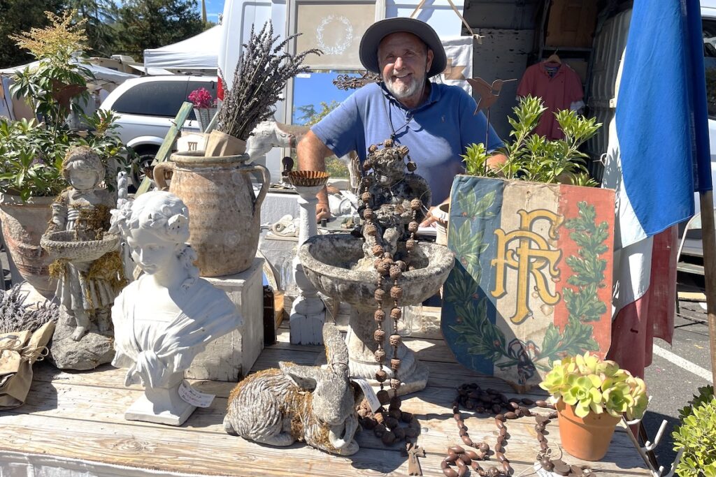 Man poses with French antiques.