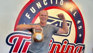 Man holds kettle bell in front of sign saying Functional 45 Training
