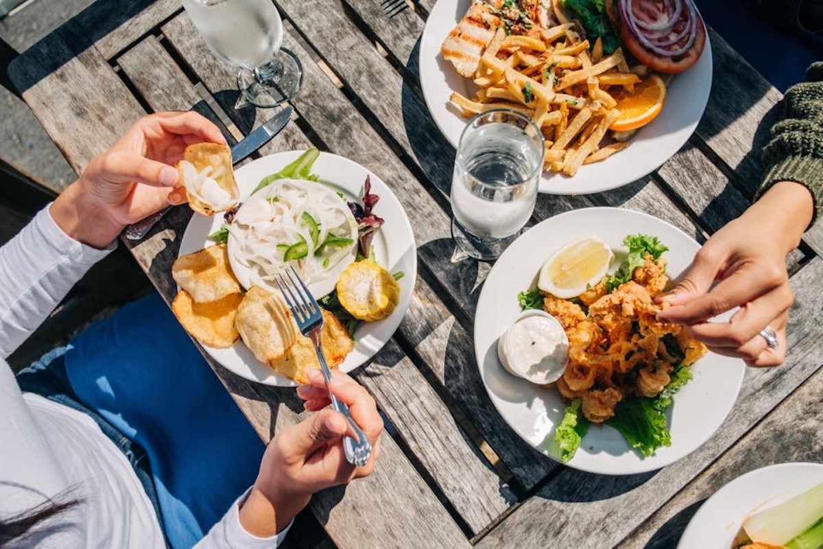 outdoor table with plates of food like a dip with chips, calamari and french fries at Mountain Home Inn