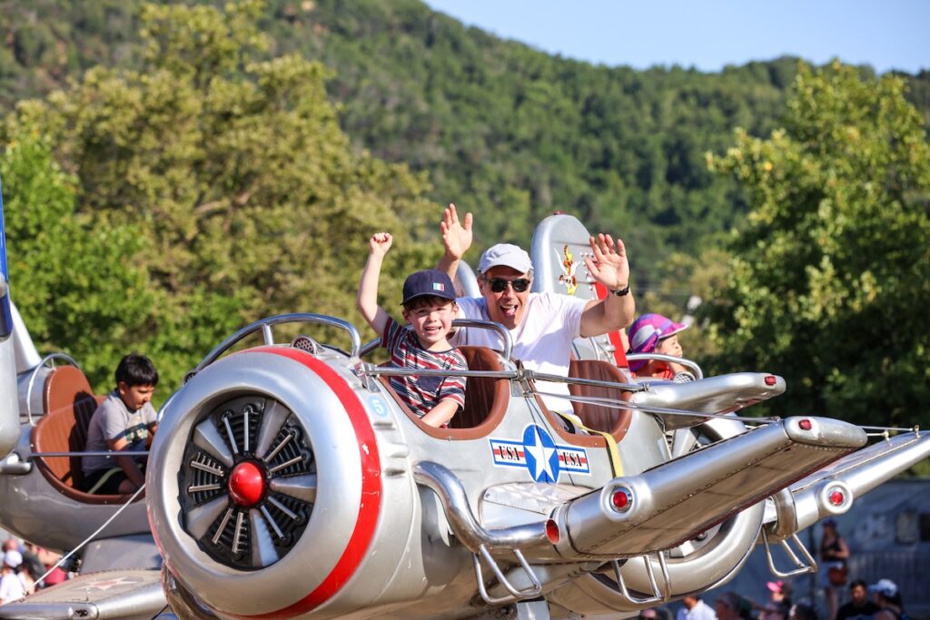 Kid and father wave from a ride at Marin County Fair