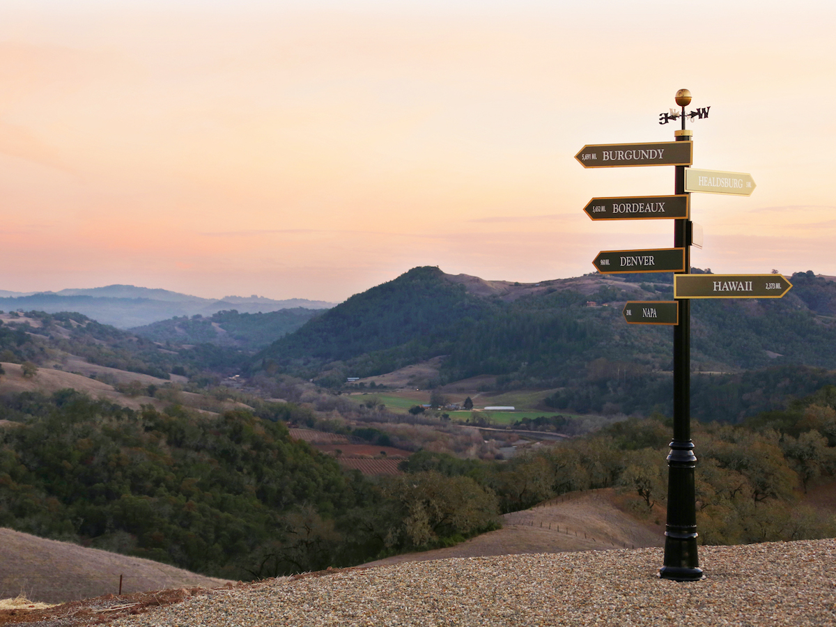 A signpost on a hill points to different places, including Burgundy, Healdsburg, Denver, Hawaii, at the Jordan Winery Estate in Healdsburg, Sonoma Wine Country