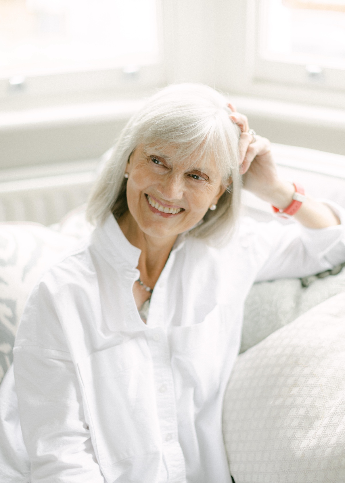Author Jackie Winspear sitting on couch