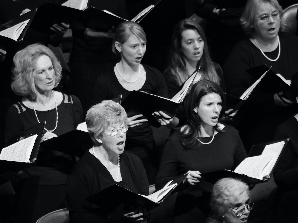 Black and white image of chorus singers, dressed in black and holding sheet music, part of Marin Oratorio's December concert