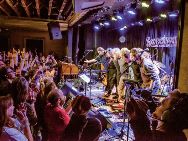 A band takes a bow onstage at Sweetwater Music Hall as the crowd cheers.