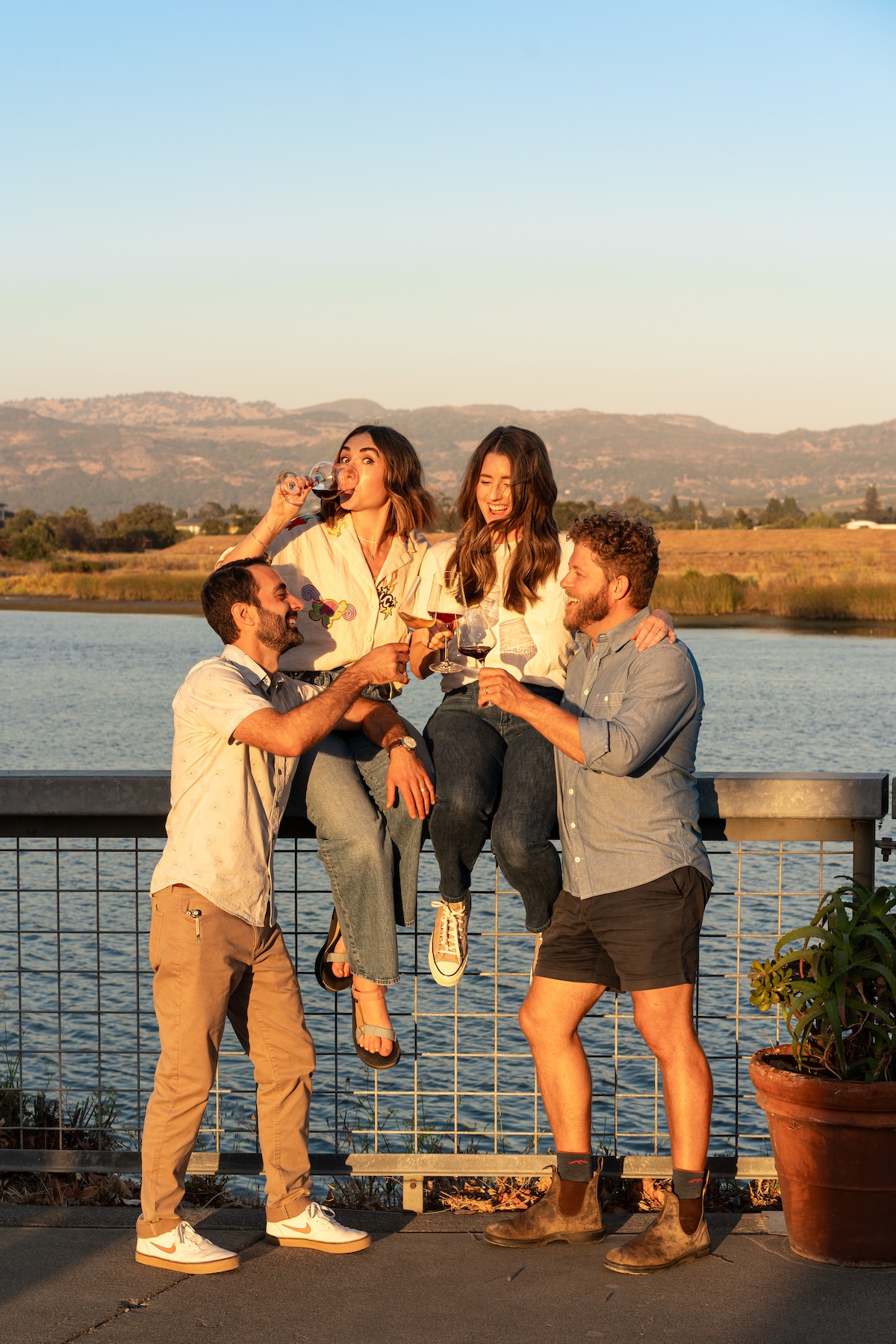 Friends drinking wine by the river at the River Club