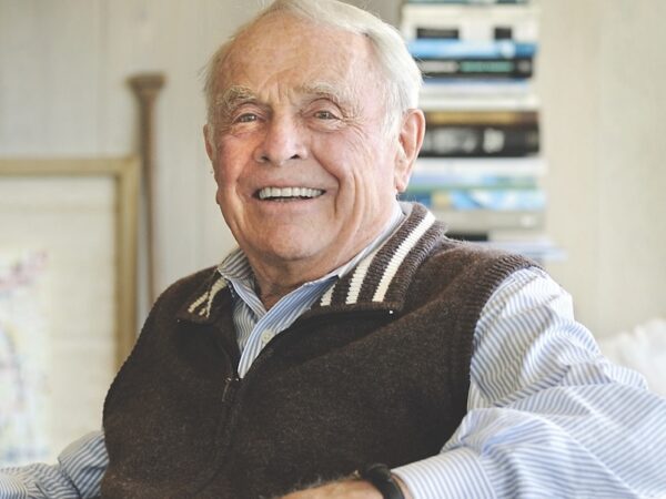 Activist Martin Griffin wears a brown sweater vest over a collared shirt and sits in a chair.