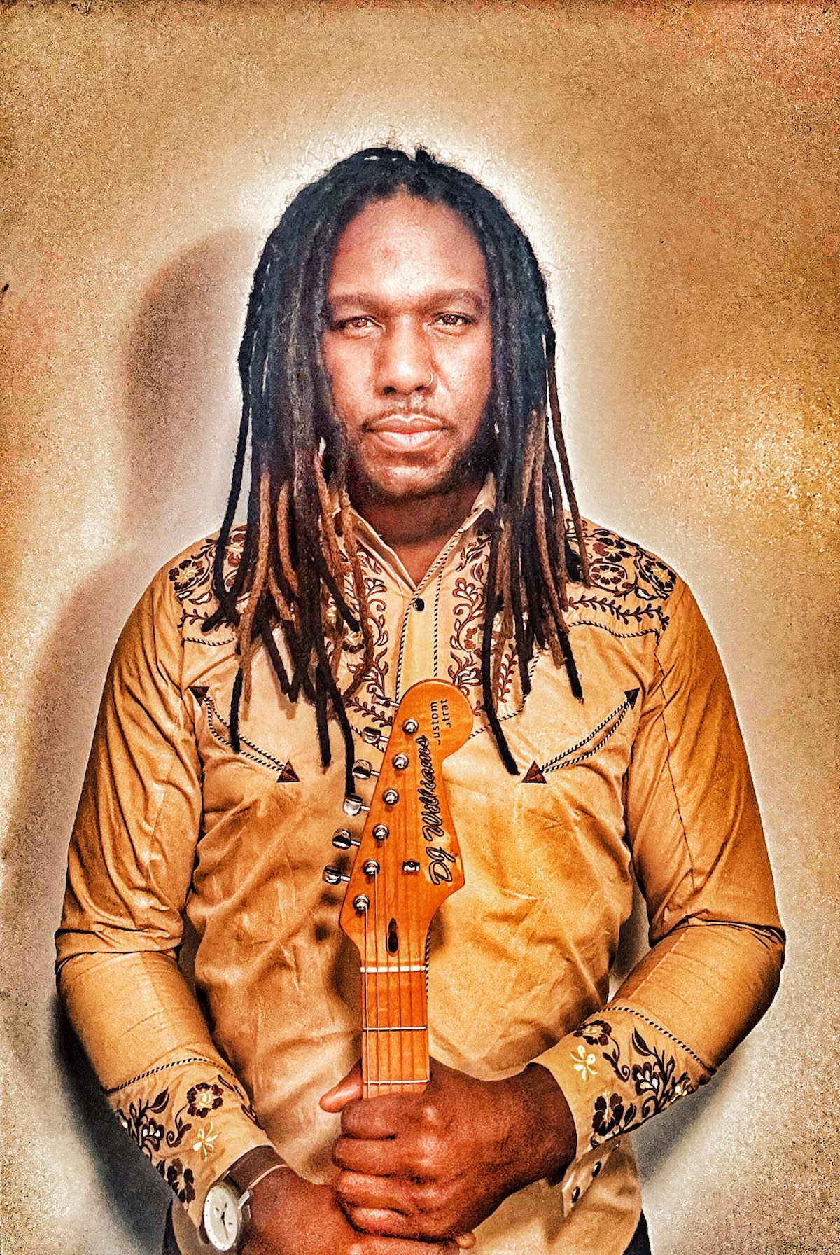 DJ Williams dressed in gold holding guitar