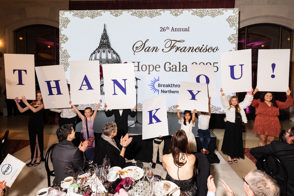 A group of people holding up signs that each have a letter, altogether spelling "Thank you!"