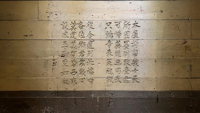 Chinese characters carefully carved into aged wooden walls, capturing the emotions of detained immigrants.