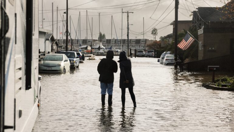 Two people stand in a king tide