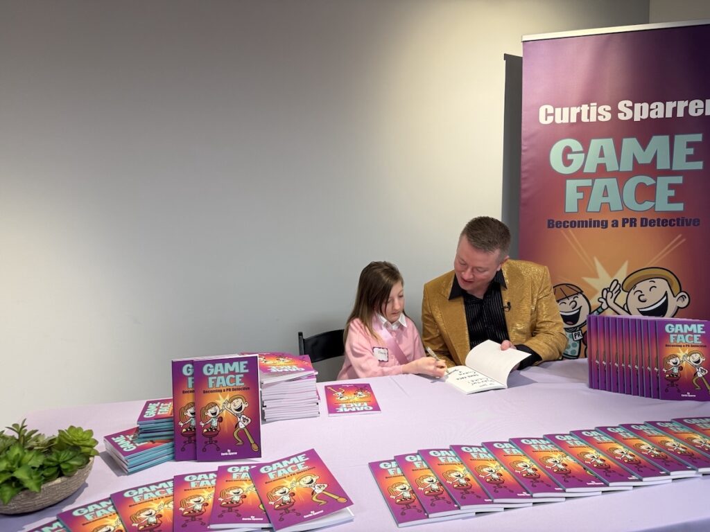 Curtis and niece Sloan sign a copy of their book