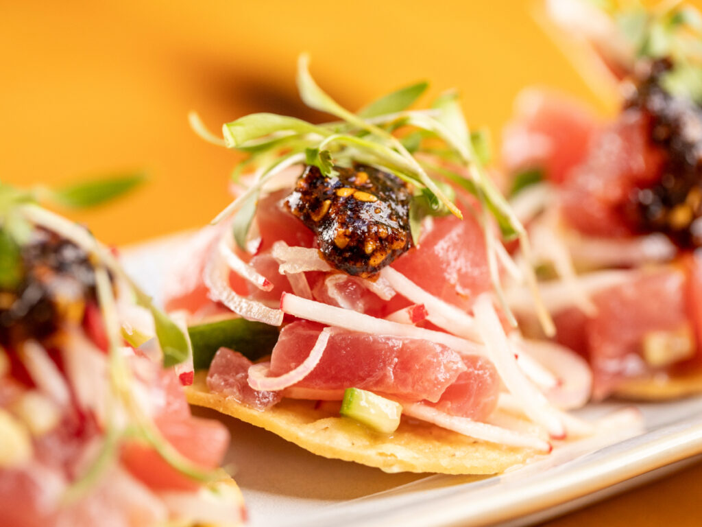 Ahi tuna tostada with salsa macha and fresh toppings on a crispy tortilla.