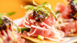 Ahi tuna tostada with salsa macha and fresh toppings on a crispy tortilla.