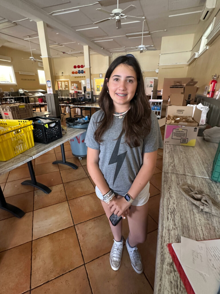 Now 14, Mia Slowe stands inside a community kitchen in San Rafael, where she continues to prepare and donate bag lunches for the homeless and food insecure.