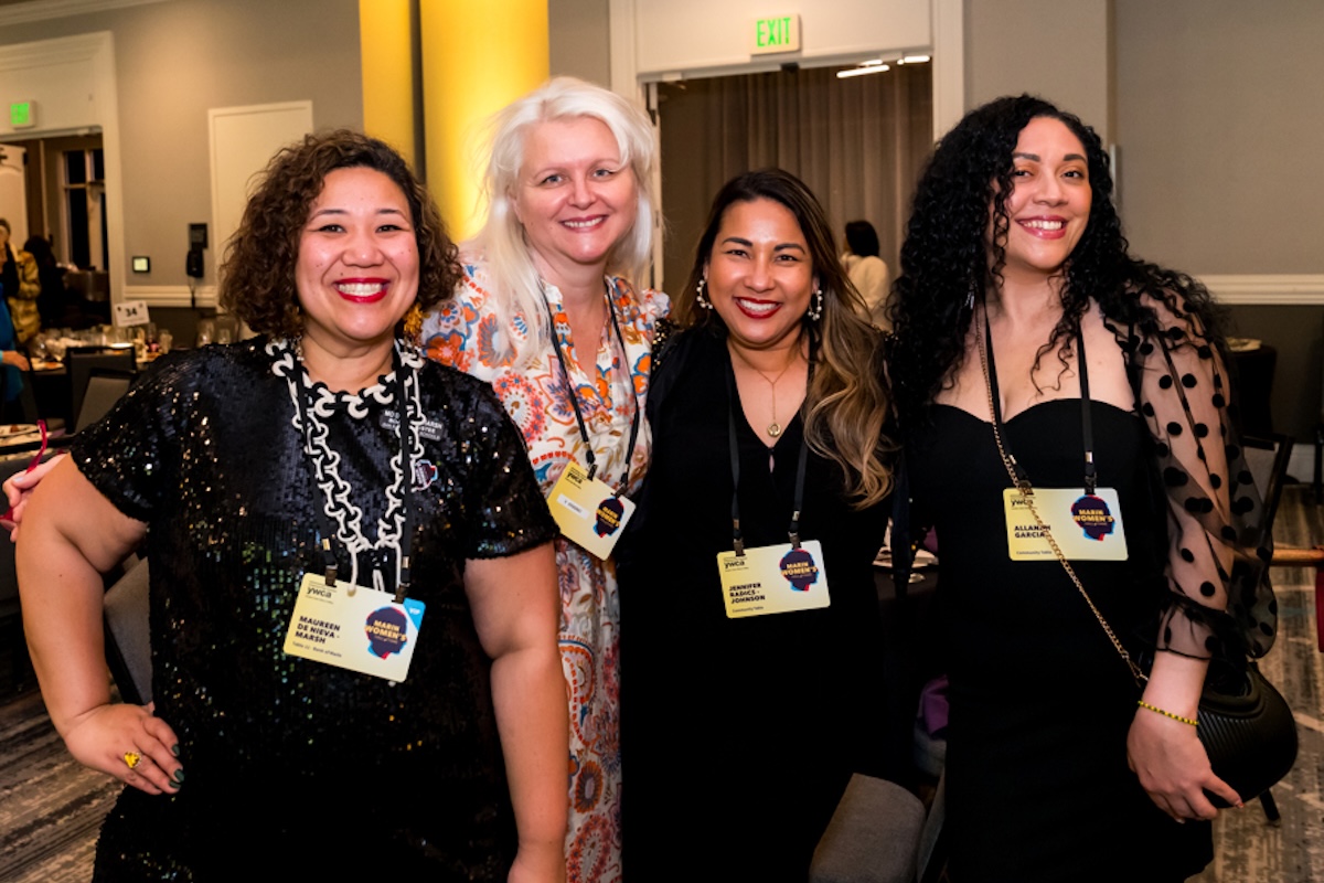 A group of four women wearing yellow badges.