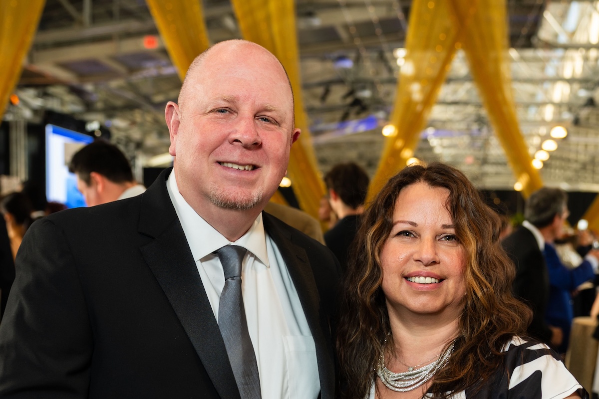 A man wearing a suit and tie with a woman wearing a silver necklace.