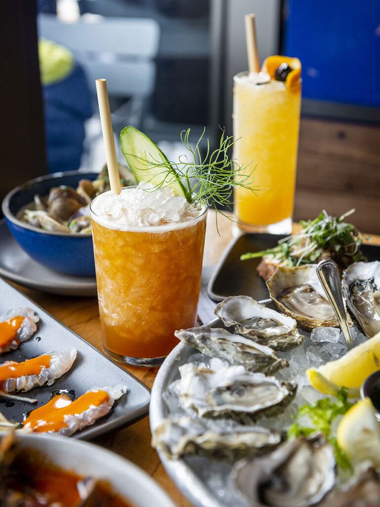 Seafood platter with cocktails and eco-friendly straws.