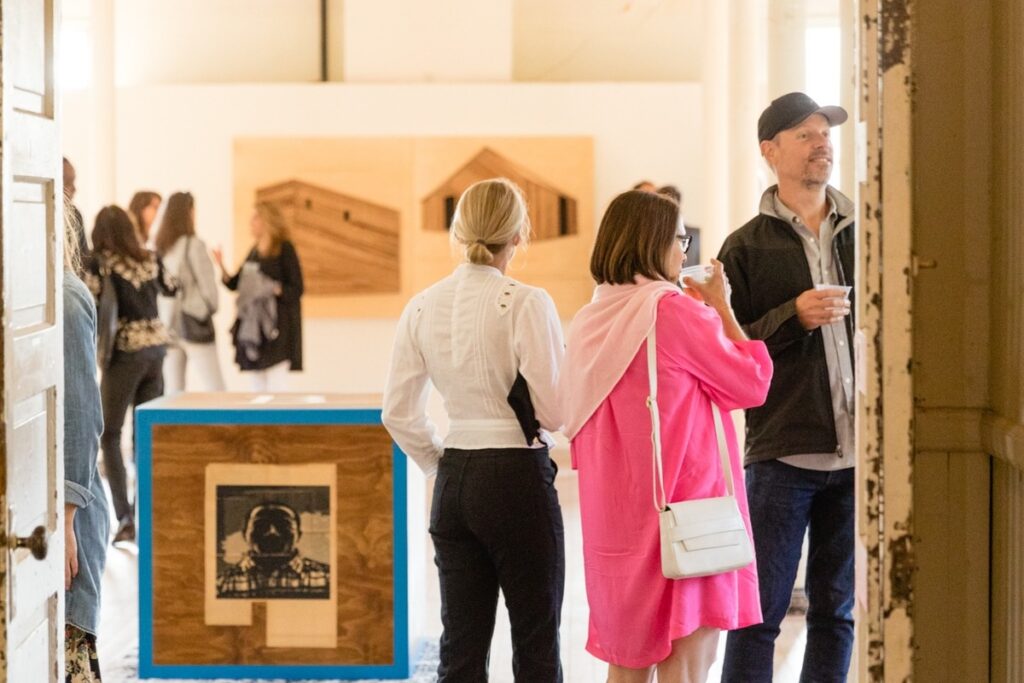 People walk around an art gallery.