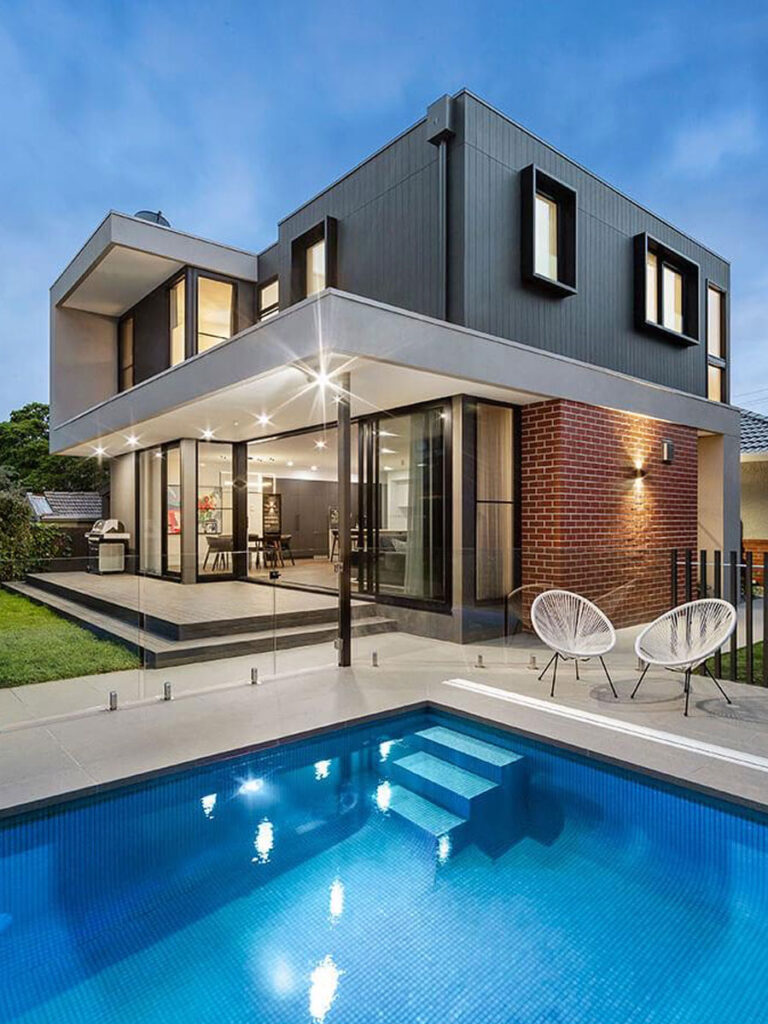 Modern home featuring a pool and a spacious patio area, surrounded by lush landscaping.