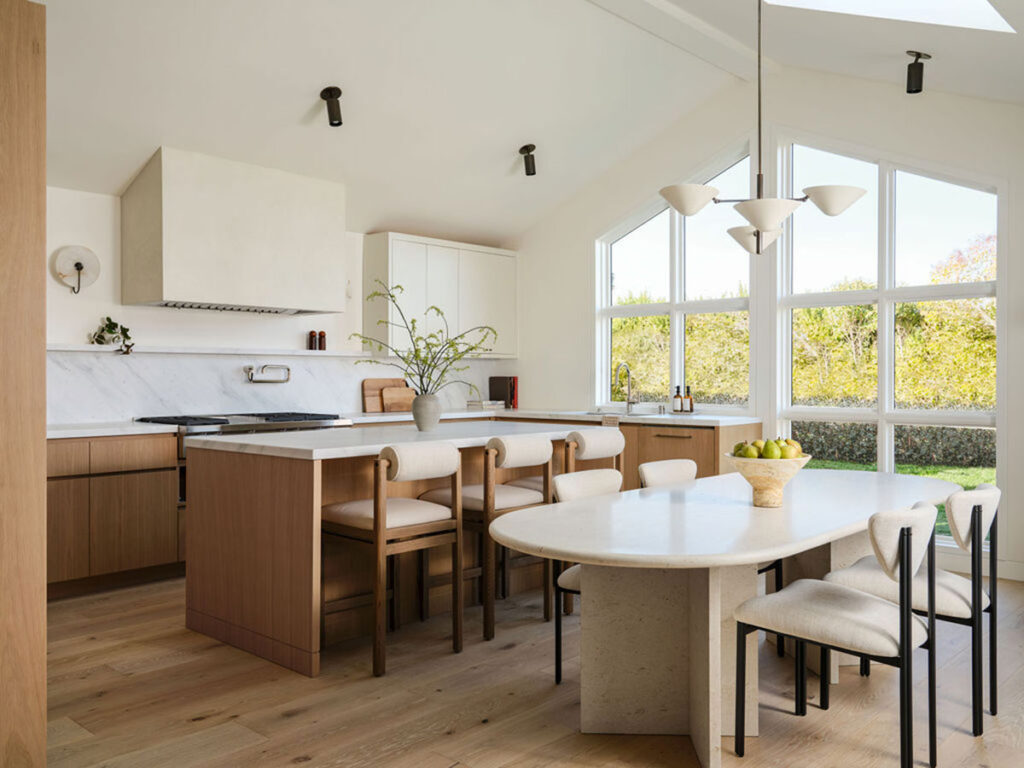 A cozy kitchen with a dining table and four chairs, showcasing cabinets and kitchenware in the surrounding area.
