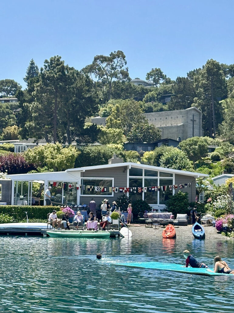 A group of people paddling on stand-up boards in calm water, enjoying a sunny day outdoors.