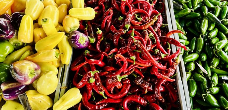 yellow, red and green peppers at a farmers market
