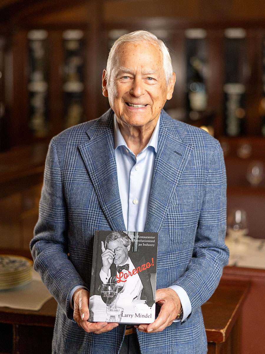 Larry Mindel holding a book named 'Lorenzo'