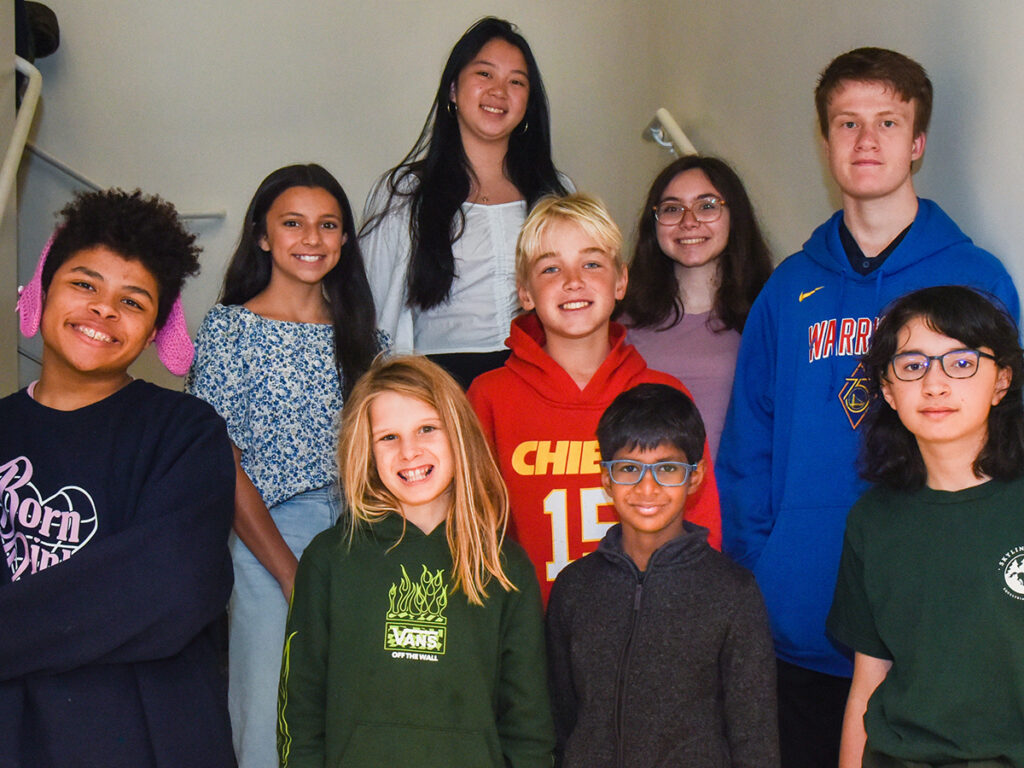 A cheerful group of young people standing close together, posing for a group photo.