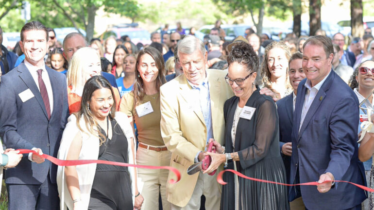 Community Action Marin CEO Chandra Alexandre delivers remarks at the podium, joined by Marin County Supervisor Eric Lucan, Assemblymember Damon Connolly, and Novato Mayor Tim O’Connor during the ribbon-cutting ceremony under red and white balloons.