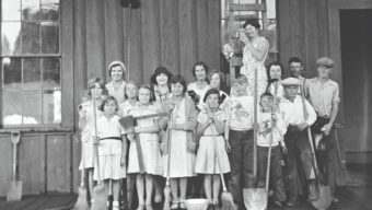 Historic photo of West Marin (Tomales) 4-H Club members with brooms and shovels after cleaning a railroad office, circa 1920s.