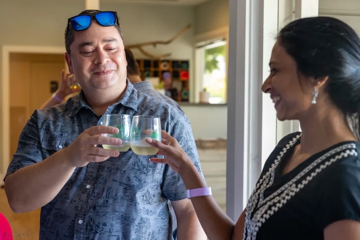A man and a women cheers their cups.