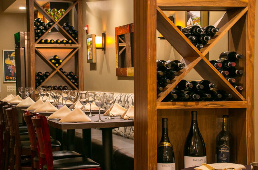 A stylish dining area with wine bottles and decorative wine racks lining the walls.