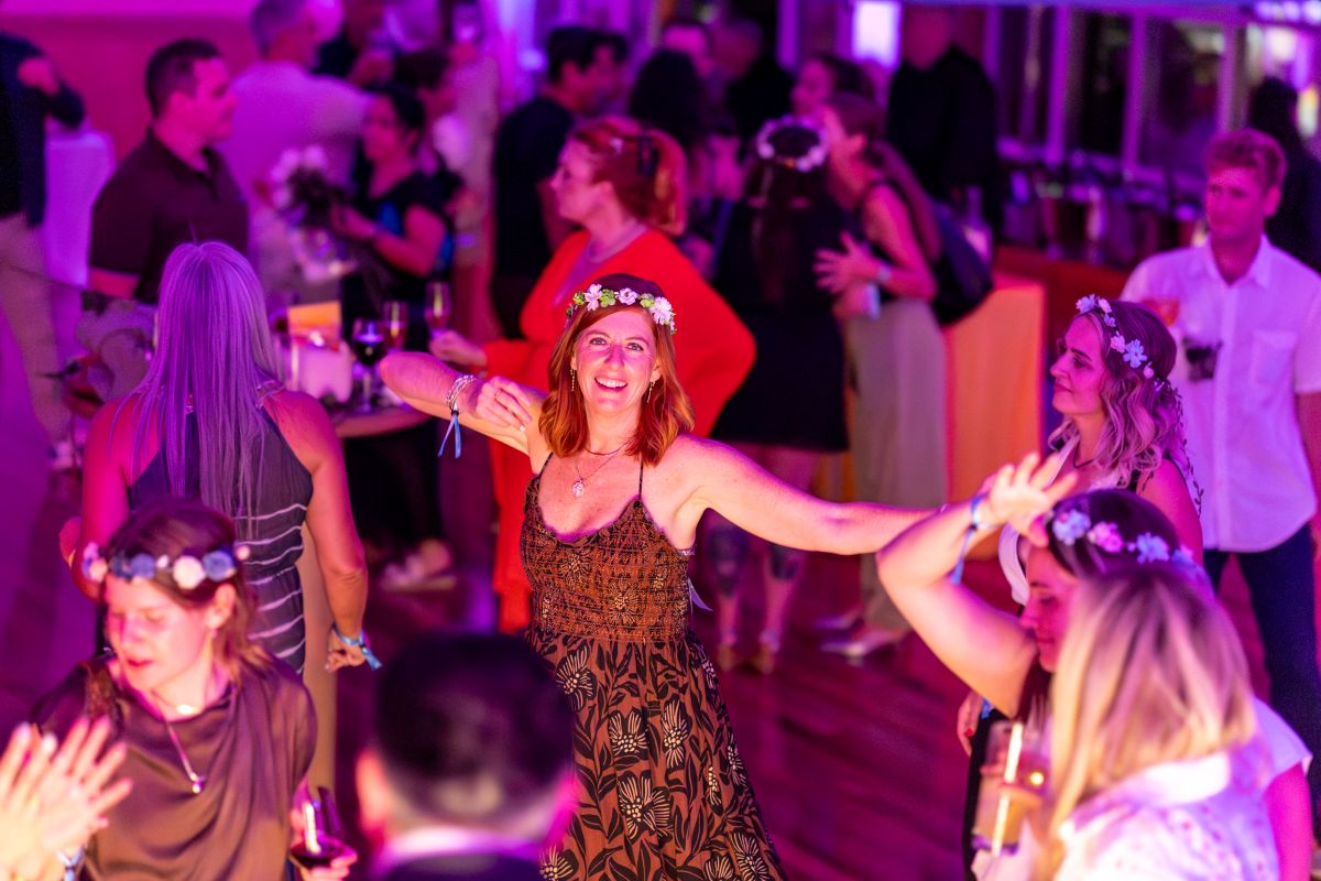 Guest wearing a flower crown dancing joyfully at the Best of the County Bash.