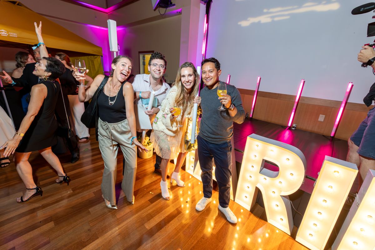 Group of friends posing together beside large illuminated MARIN letters.
