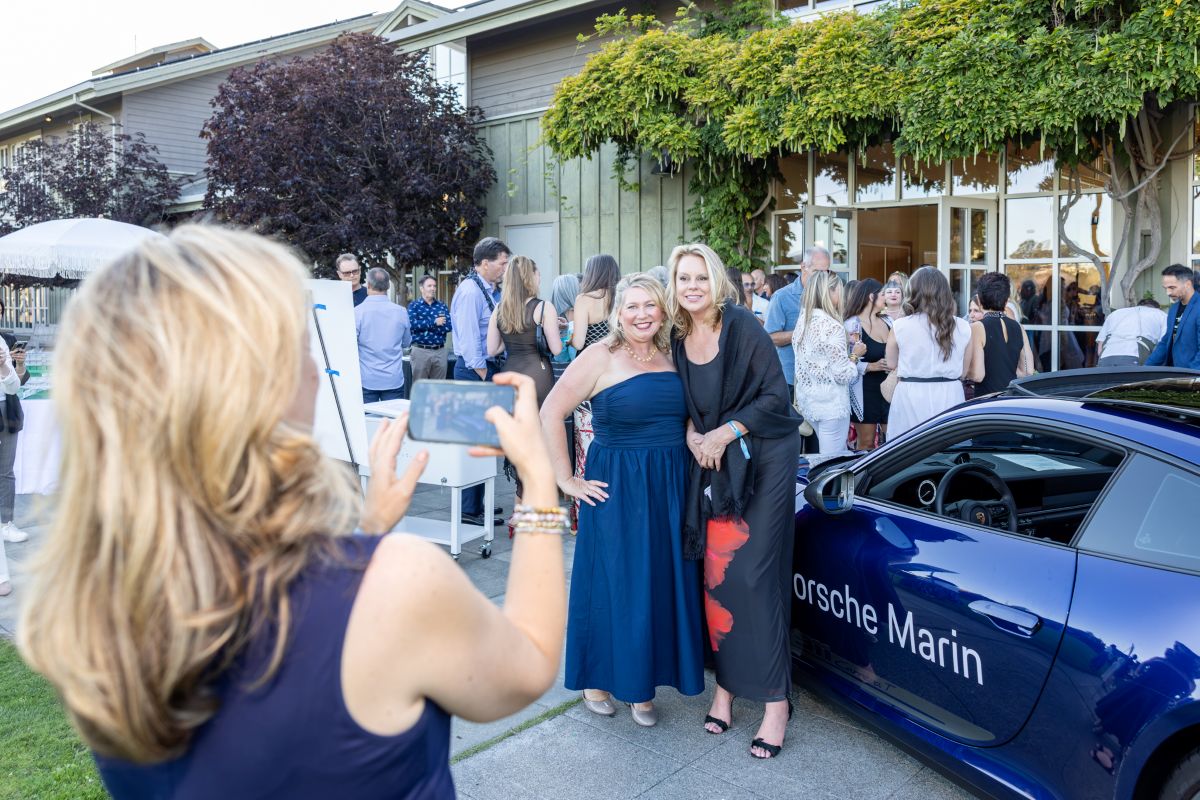 Attendees posing outside next to a Porsche Marin car at Best of the County Bash.