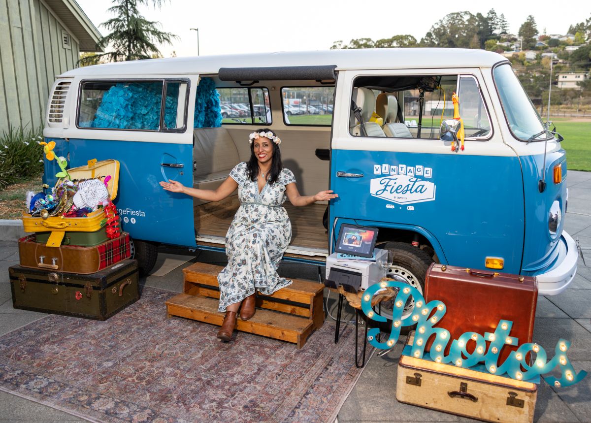 Guest posing with props at Vintage Fiesta photo bus.