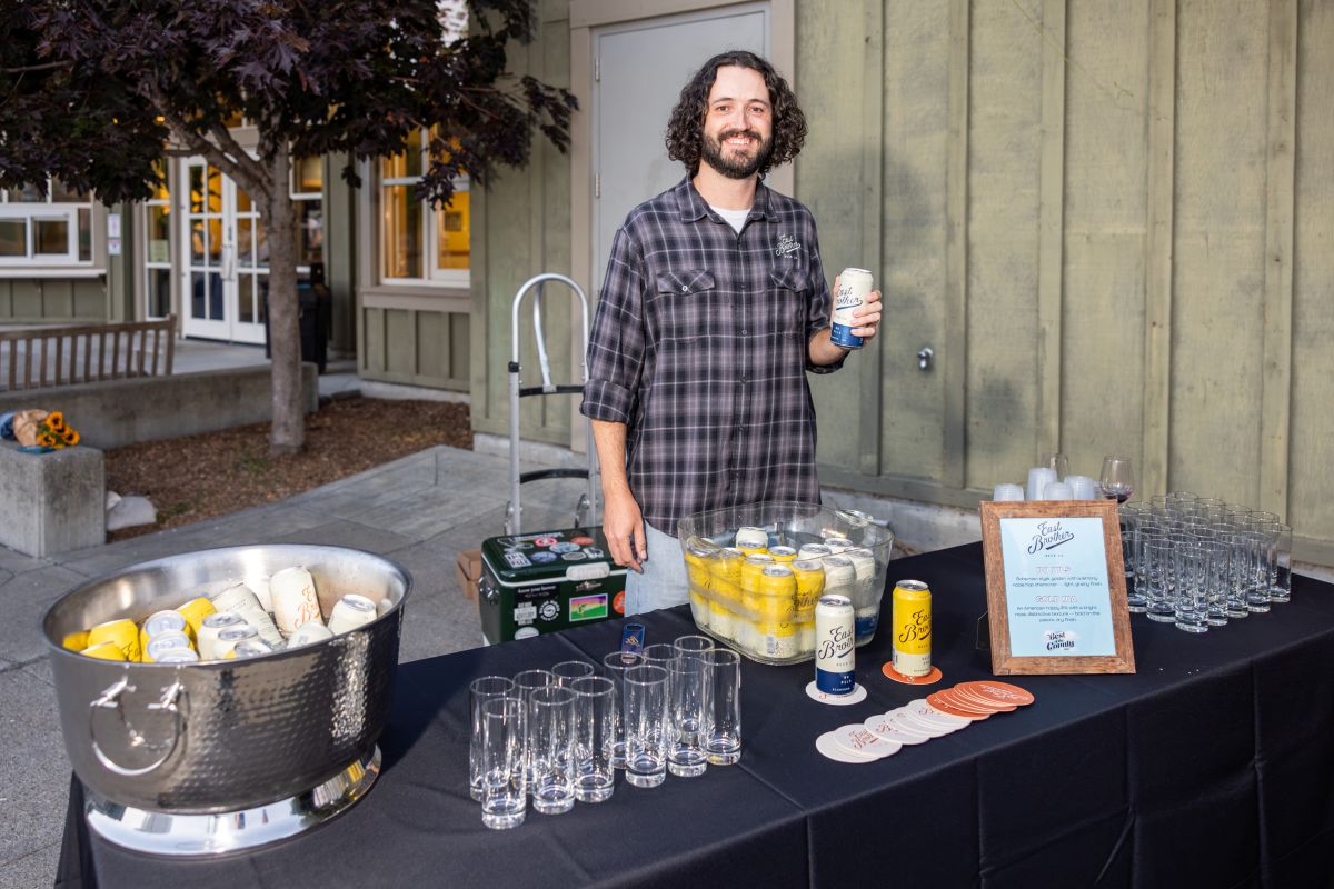 Vendor with table of East Brothers beers and glassware.